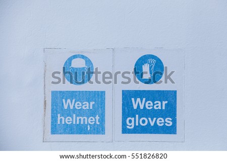 Close up shot of some signs with mandatory helmet and gloves.