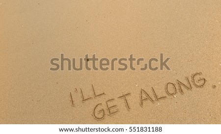 Handwriting words "I'LL GET ALONG" on sand of beach