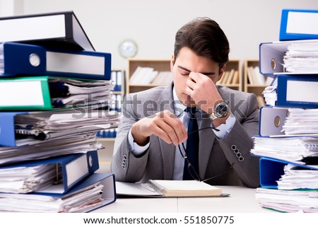 Busy businessman under stress due to excessive work Royalty-Free Stock Photo #551850775