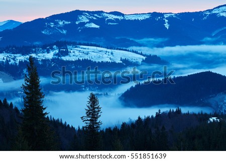 Beautiful view of the blue winter mountains and hills in Carpathians on the sunrise