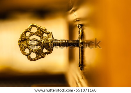 macro shot of an antique and weathered vintage key in his keyhole Royalty-Free Stock Photo #551871160