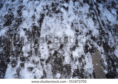 the view of the background of ice with footprints on the road in winter