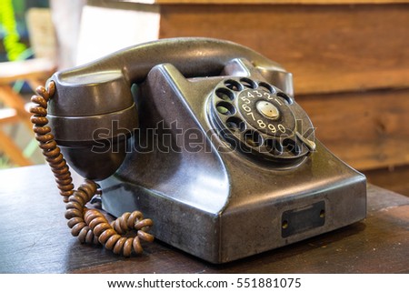 Old telephone on wooden desk Royalty-Free Stock Photo #551881075