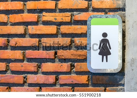 Women toilet sign on brick wall