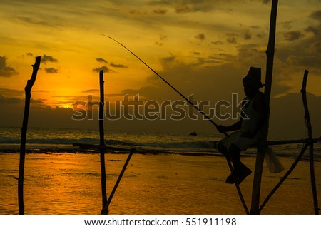 Silhouettes of the traditional Sri Lankan stilt fishermen at the sunset in Weligama, Sri Lanka. Stilt fishing is a method of fishing unique to the island country of Sri Lanka