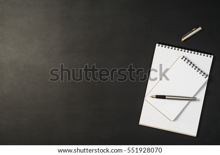 Black chalkboard office table or desk seen from above. Top view product photograph. Shool or university concept image with set of accessories