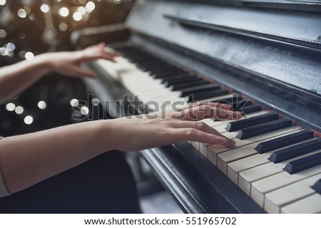 The girl plays piano, close up , white and black keyboard