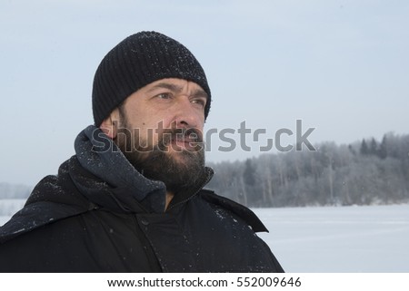 Portrait of a mature, bearded and mustachioed man in winter clothes.