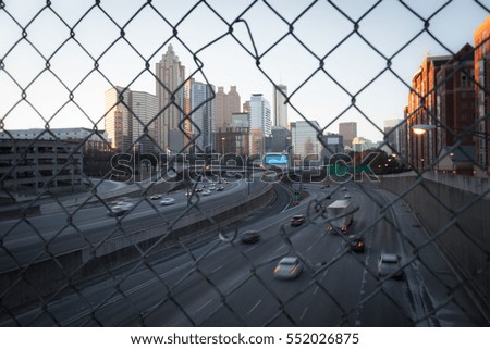 Morning city skyline through the wire mesh fence. Vintage style cityscape background