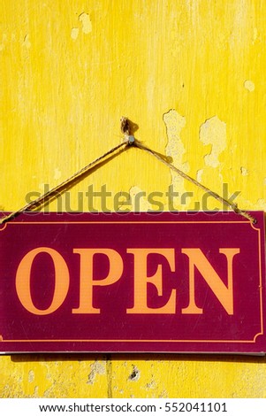 Sign on the yellow wall say "Open" 