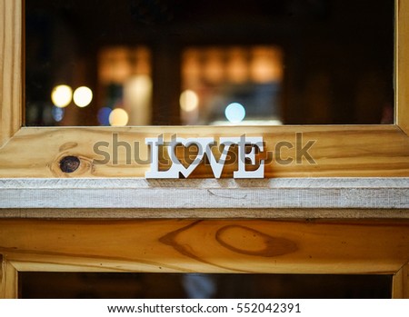 Wooden letter word LOVE on wooden door with light bokeh. Valentine concept