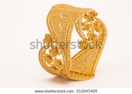 Indian ethnic designed gold bangles in white background. Royalty-Free Stock Photo #552045409