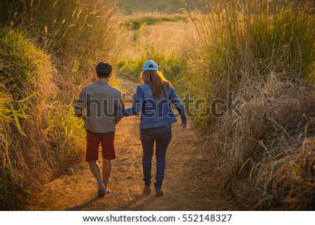 Man and woman asia are walking hand in hand. Emotion love with atmosphere during sunrise.
