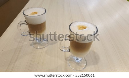 Two cups of latte on a table
