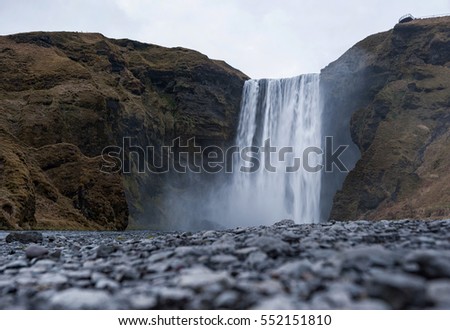 Skogafoss Waterfall In Iceland. Long Exposure Photo Shoot with Blue Sky 