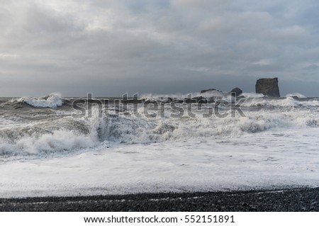 Black Sand Beach Reynisfjara in Iceland. Ocean Waves and Rocks in Background.