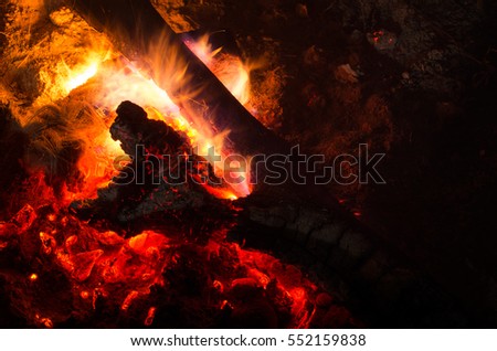 Burning firewood in the fireplace closeup, glowing logs, fire and flames.