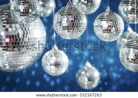 Mirrored disco balls and Christmas decorations against blue background