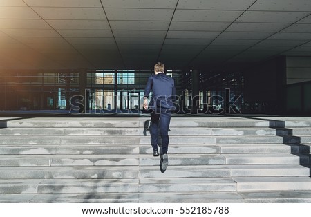 Back view of running to doors businessman. Horizontal outdoors shot Royalty-Free Stock Photo #552185788