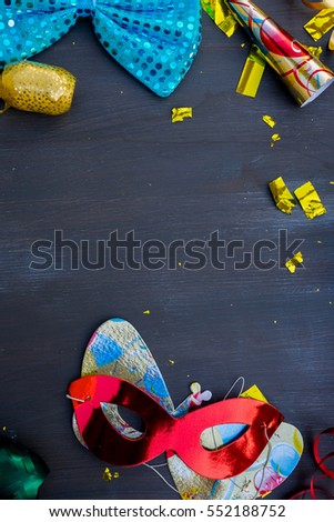 Masquerade decorations and accessories frame on dark wooden background