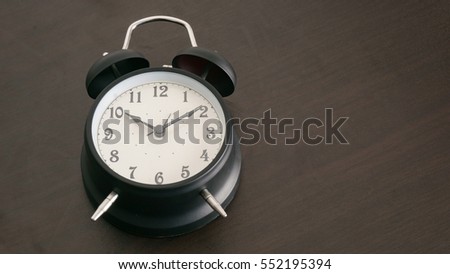 Black alarm clock on black desk
