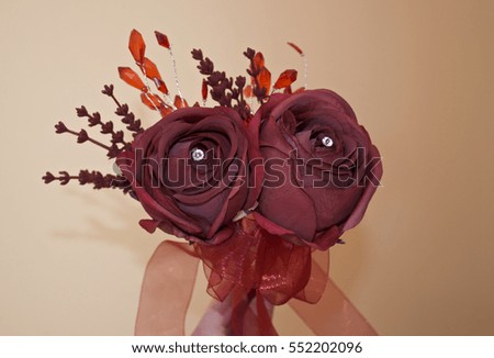 Red rose bouquet with diamonds in the centre and red ribbon, orange/ red background with ornamental leaves