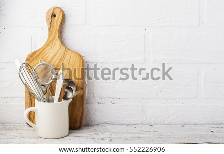 Kitchen tools, olive cutting board on a kitchen shelf against a white brick wall. Selective focus  Royalty-Free Stock Photo #552226906