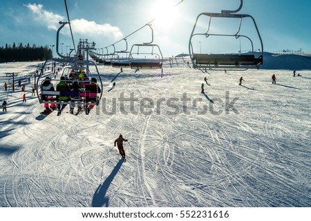 Skiers on the lift - skiing on slope in Tylicz village Royalty-Free Stock Photo #552231616