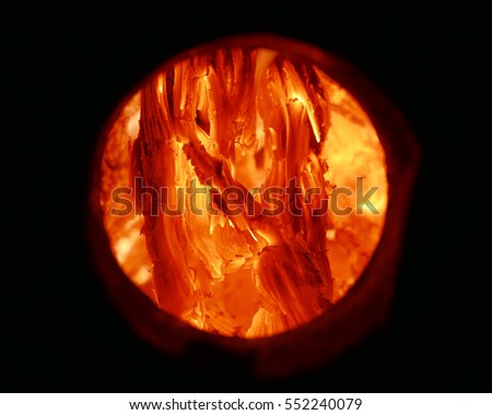 Concept of the sun being powered by fossil fuels, Artificial sun abstract. Circular texture of burning wood charcoal and flames close up. 