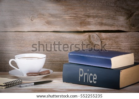 Price. Stack of books on wooden desk