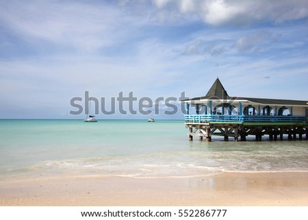 Beautiful day with a view out to sea & the pier of Runaway Beach, Antigua, Caribbean. Royalty-Free Stock Photo #552286777