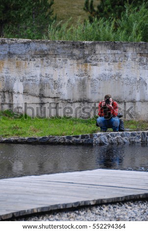 Photographer shooting wit his camera by the river