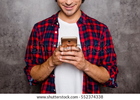 Close up of happy young man typing message on smartphone