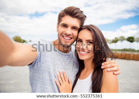 Loving cheerful happy couple taking selfie in the city