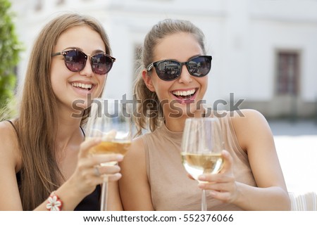 Portrait of two young brunettes having summer wine fun.