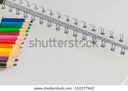 Abstract soft blurred and soft focus of multicolor pencils with the white notebook and copy space background.