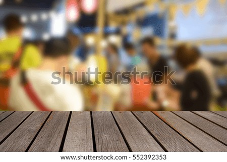 blurred image wood table and food at night festival with bokeh background