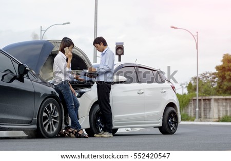 Woman driver calls for instruction during insurance agent review the dammage of the car after accident Royalty-Free Stock Photo #552420547