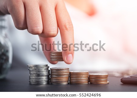 Close up female hand stacking coins and counting on the table. concept of Saving money, economy, investment, growing business and wealth. Royalty-Free Stock Photo #552424696