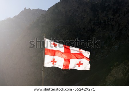 Georgia flag on a background of mountains Royalty-Free Stock Photo #552429271