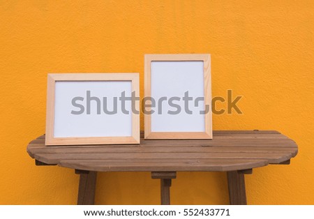 Two photo Frame on a wooden on Yellow background .