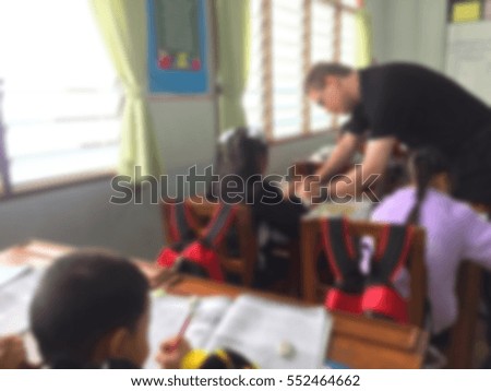 Blur kids and teacher  in the classroom for background usage.