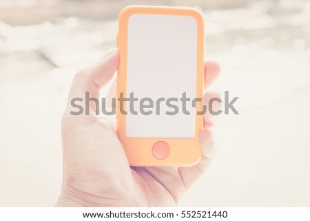 Vintage tone of cropped shot view of hands holding smart phone with blank copy space screen for your text message or information content, Smart photo with blurred background at outdoor and park.
