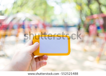 Vintage tone of cropped shot view of hands holding smart phone with blank copy space screen for your text message or information content, Smart photo with blurred background at outdoor and park.