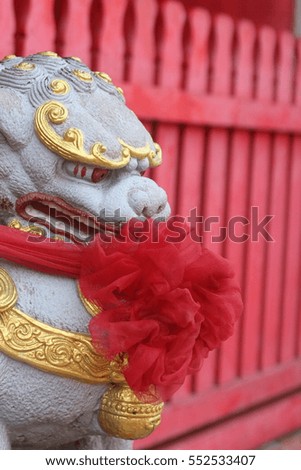 Chinese stone lion with red temple background