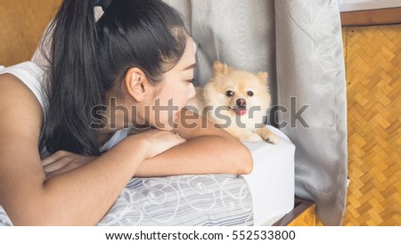 Asian woman relax on bed with her dog in bamboo bedroom.