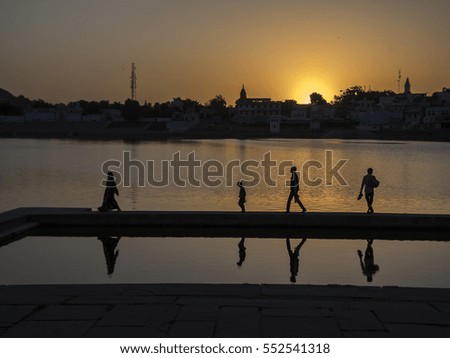 silhouette of people walking down the lake in Pushkar, India.
