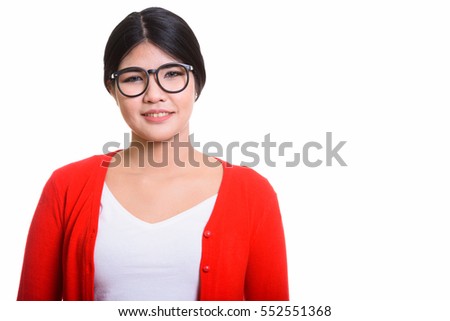 Studio shot of young happy Asian nerd woman smiling isolated against white background