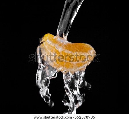 oranges in drops of water isolated on black background closeup
