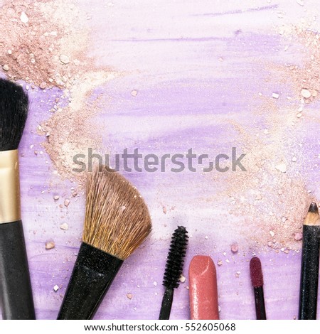 Makeup brushes, lipstick and pencil on a light purple background, with traces of powder and blush on it. A square template for a makeup artist's business card or flyer design, with copyspace